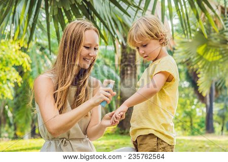 Mom And Son Use Mosquito Spray.spraying Insect Repellent On Skin Outdoor.