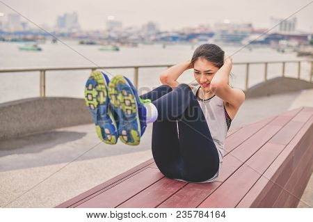 Sports Concept. Beautiful Girl Is Exercising On The Beach With Warm Up. Beautiful Girl Is Happy To E