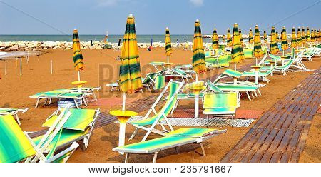 Sun Umbrellas And Loungers In The Deserted Beac