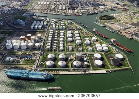 Aerial View Of Oil Tankers And Storage Silo Tanks At A Petrochemical Terminal Port.