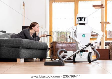 Woman Is Enjoying Her Leisure While A Robot Is Doing The Work In The Household. Aai Is Vacuuming The