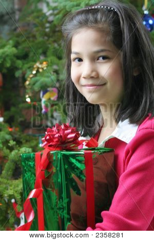 8 歳のクリスマス プレゼントを持って女の子