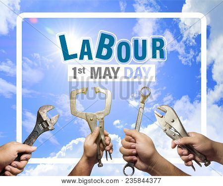 Labour Day Concept,1st May, The Hands Of A Mechanic Man Is Holding Instruments With A Blue Sky And C