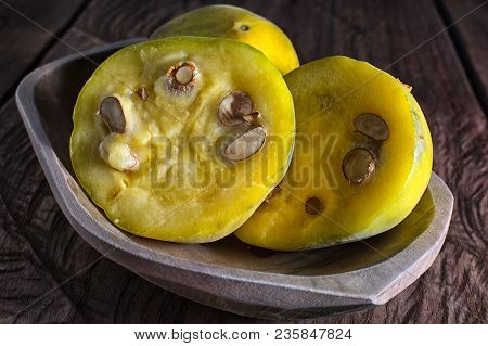 Cut Half Rare Araza Fruits In A Wooden Bowl On Rustic Background