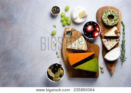Assortment Of Hard, Semi-soft And Soft Cheeses With Olives, Grissini Bread Sticks, Capers, Grape, On