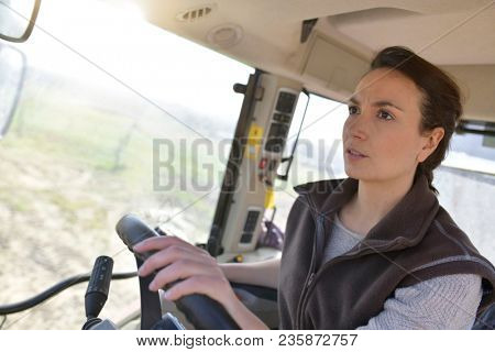 Farmer woman driving tractor