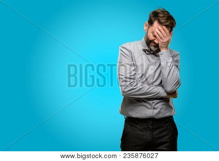 Middle age man, with beard and bow tie stressful keeping hands on head, tired and frustrated