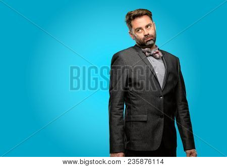 Middle age man, with beard and bow tie with sleepy expression, being overworked and tired
