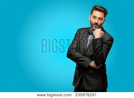 Middle age man, with beard and bow tie with crossed arms confident and serious