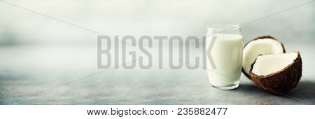 Coconut Vegan Milk Non Dairy In Glass And Coconut Fuit Halves On Grey Concrete Background With Copy 