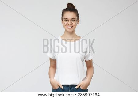 Young European Woman Standing With Hands In Pockets, Wearing Blank White Tshirt With Copy Space For 