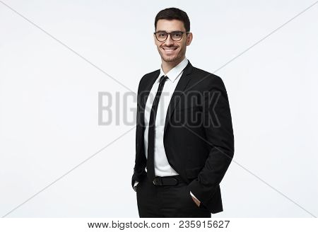 Indoor Picture Of Young Business Man In Glasses Pictured Isolated On Grey Background Looking Straigh