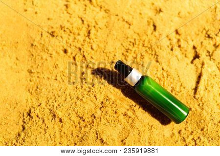 Bottle Of Sunscreen In Sand Against Sea Background With Copyspace. Vacation And Travel Wallpaper. Sk