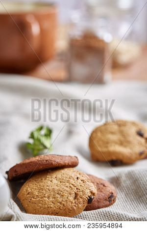 Side View Of A Plate Of Chocolate Chip Cookies On A White Plate Homespun Tablecloth Illuminated With
