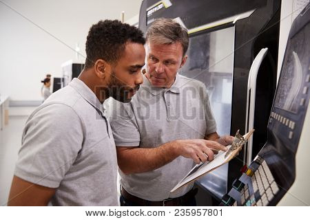 Engineer Training Male Apprentice To Use CNC Machine In Factory