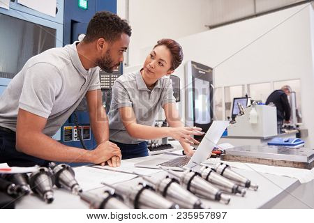 Two Engineers Using CAD Programming Software On Laptop