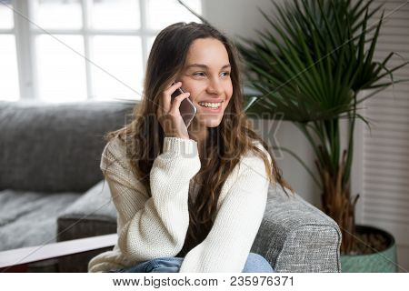 Smiling Millennial Mestizo Woman Talking On The Phone At Home, Happy Young Girl Holds Cellphone Maki