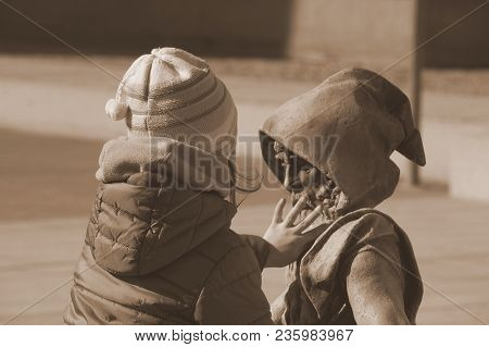Little Dwarf And Girl In A Gnome. Childhood, Nature And Culture Dialog Concept. Statue, Sculpture. S