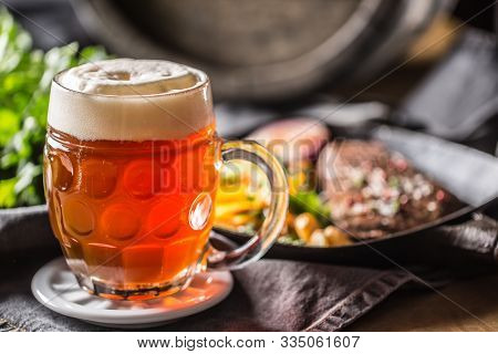 Glass Of Red Beer In Pub Or Restavurant On Table With Delicoius Food.