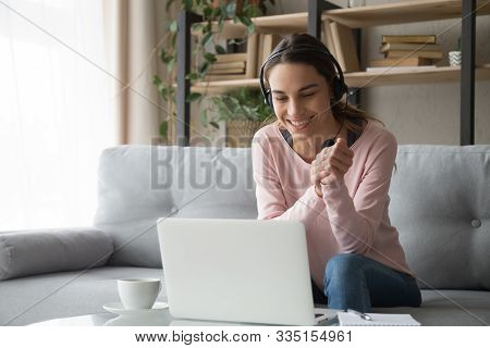 Smiling Woman Watching Webinar Sitting On Couch At Home