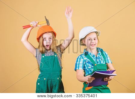 Little Kids In Helmet With Tablet And Hammer. Labor Day. 1 May. Small Girls Repairing Together In Wo