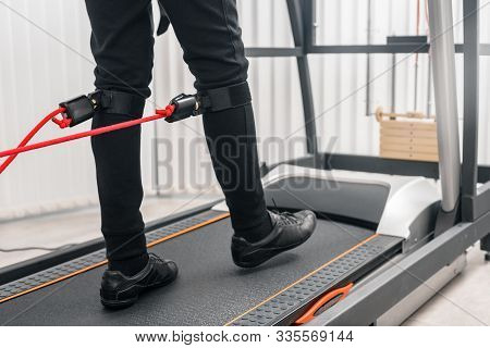 Closeup Photo Of Man Walking On Treadmill With Electrodes On His Legs