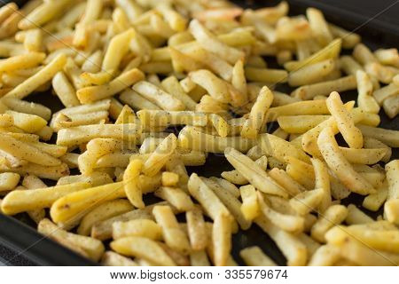 Oven Baked Potato Sticks. French Fries On Dark Baking Tray Top View. Fast Food Potato Skins On A Bak