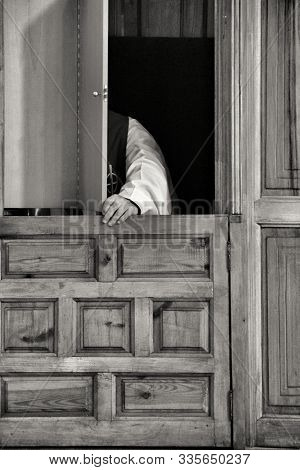 Priest In Confessional Confessing To A Faithful In Spain