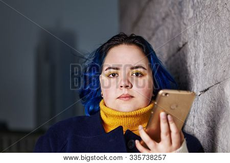 Portrait Of Pretty Teenage Girl With Blue Hair, Who Is Standing Near Wall On The Street With Smatrph
