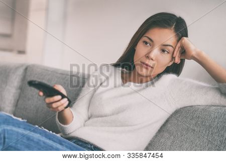 Bored woman watching boring tv shows having nothing to watch on television. Movie night sucks.