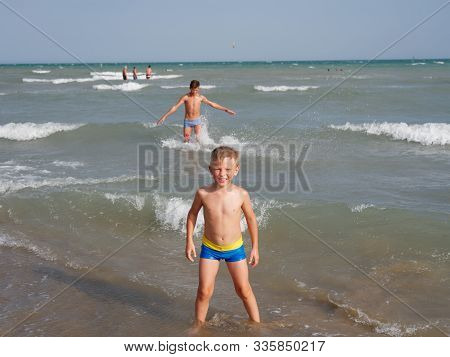 Children Swim In The Sea On The Beach In Bibione, Italy