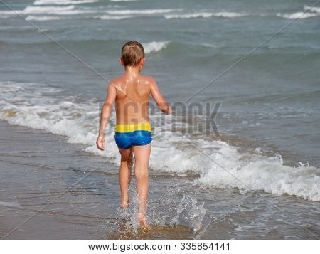 Children Swim In The Sea On The Beach In Bibione, Italy