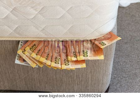 A Close Up View Of One And Two Hundred Rand Notes On A Plate With A Knife And Fork In The Middel To 