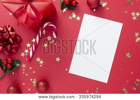Christmas Background With Blank Paper, Red Gift Box With Ribbon Bow On Red Background And Golden Spa