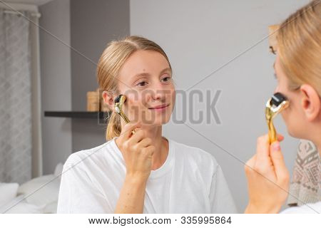 Dermaroller. Woman Is Making Procedure On Face With Meso Roller In Home