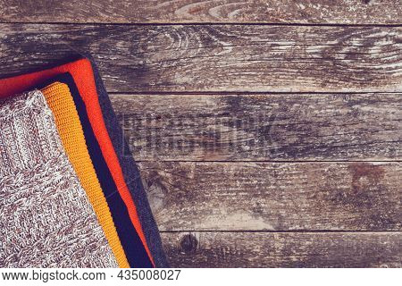 Knitted Warm Clothes On Wooden Background, Top View, Copy Space. Woolen Color Clothes, Vintage Style