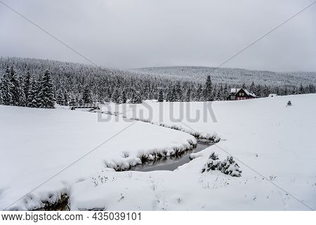 Winter In Jizerka. Snowy Landscape With Mountain Hut, Trees And Small Creek. Jizera Mountains, Czech