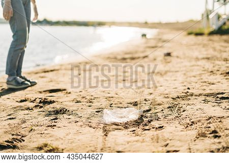 Used Plastic Wasted Water Bottle Washed Up On The Shore Of A Beach, Highlighting The Worldwide Crisi