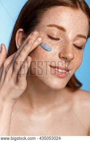 Skin Care. Vertical Portrait Of Redhead Woman Applying Clay Mask, Facial Nourishing Cream Or Daily C