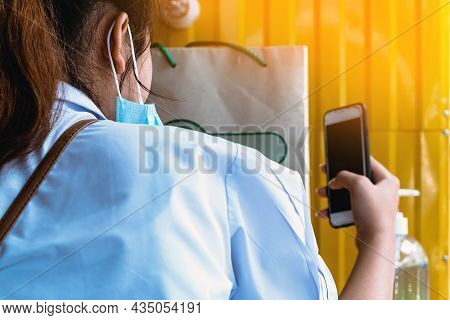 Back View Of Female Student Taking Off Medical Face Mask Doing Selfie With Smartphone. Selfie Of You