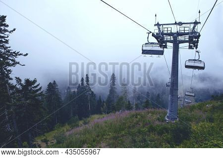 Cable Car In The Mountains With Clouds Or Fog. View From The Cable Car To The Mountain Landscape. Th