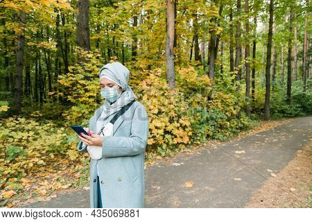 Muslim Woman With Hijab Is Wearing Face Mask Outdoors. Coronavirus, Health Care And Pandemic Concept