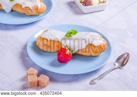 Choux Pastry Filled With Cream And Glazed On A White Plate