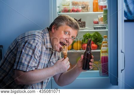 Mature Men At Fridge  With Beer And Chicken's Leg