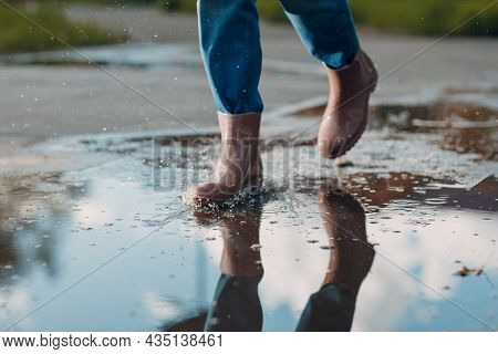 Woman Wearing Rain Rubber Boots Walking Running And Jumping Into Puddle With Water Splash And Drops 