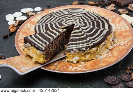 Chocolate Sliced Esterhazy Cake With Cream, Frosting, Nuts, Cinnamon And Almonds Close-up View From