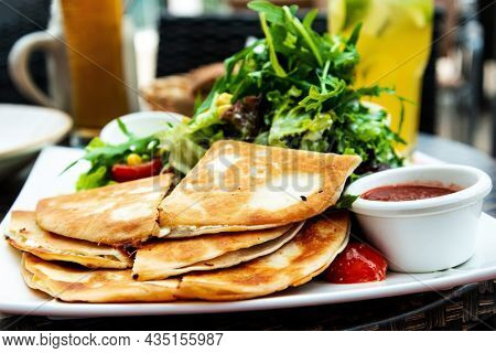 Delicious Mexican beef quesadillas with fresh lettuce and guacamole sauce