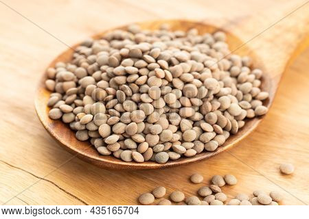 Lentil On Wooden Spoon On Table. Lens Variabilis
