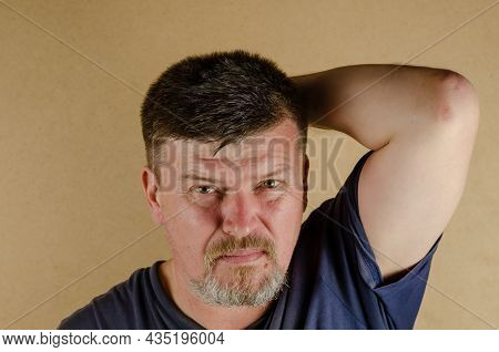 Portrait Of A 45-year-old Man Looking At The Camera. Adult Unshaven Male Indoors.
