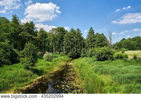 The Obra River Flowing Through The Meadow During Summer In Poland